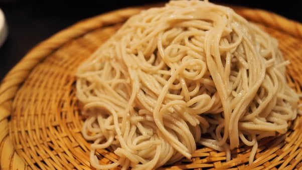 cooked soba noodles on a traditional japanese bamboo plate