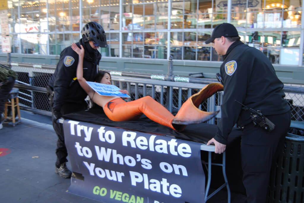 Police Carrying Mermaid Protestor