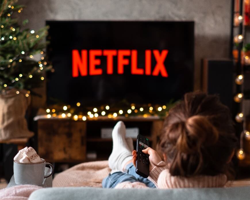 A TV displays Netflix's logo in a holiday-decorated room