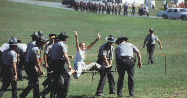 An iconic image from this protest shows PETA President Ingrid Newkirk being hauled away by police officers after she and others rushed onto the field to free the pigeons