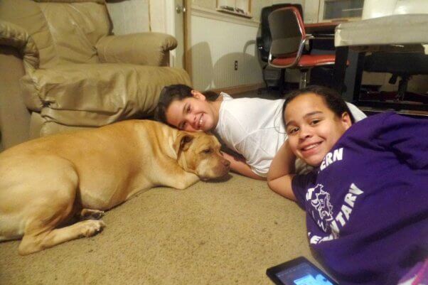 dog and two girls smiling