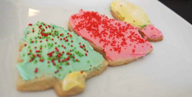 frosted vegan sugar cookies in various cut out shapes on a white plate