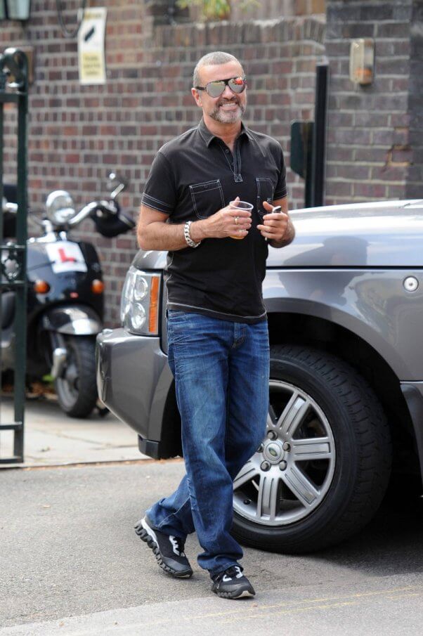 George Michael seen with an ice cool beverage as he arrives at a studio on a hot summer