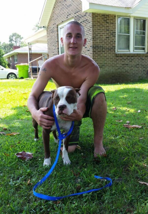 Man posing with dog on green grass