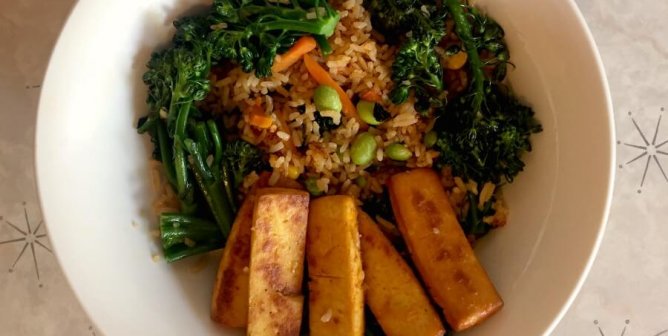 Bowl of vegetable fried rice with broccoli and baked tofu
