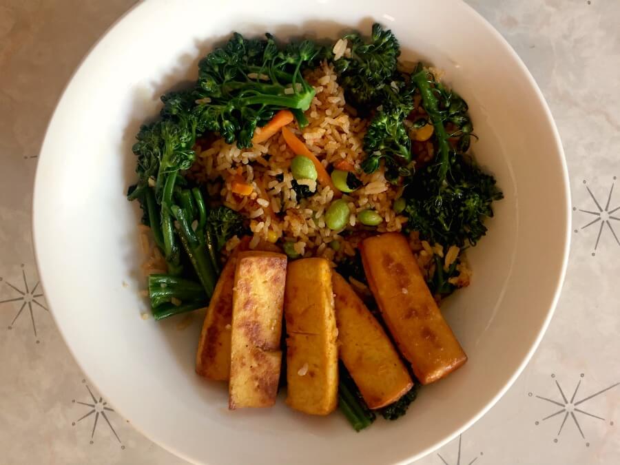 Bowl of vegetable fried rice with broccoli and baked tofu