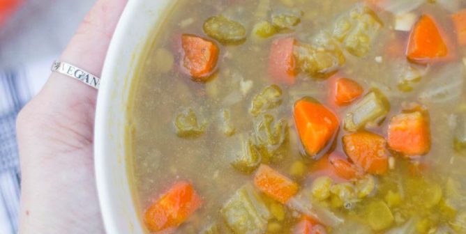 woman holding bowl of vegan split pea soup