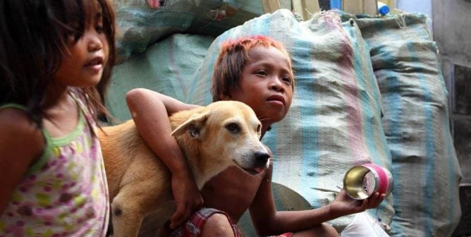 children with a dog helped by money raised through PETA's Global Compassion Fund