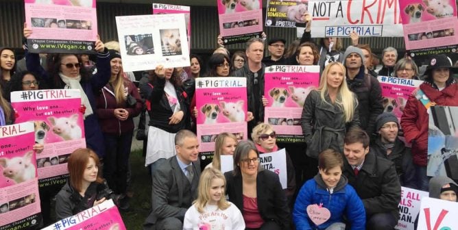 Anita surrounded by people holding colorful signs