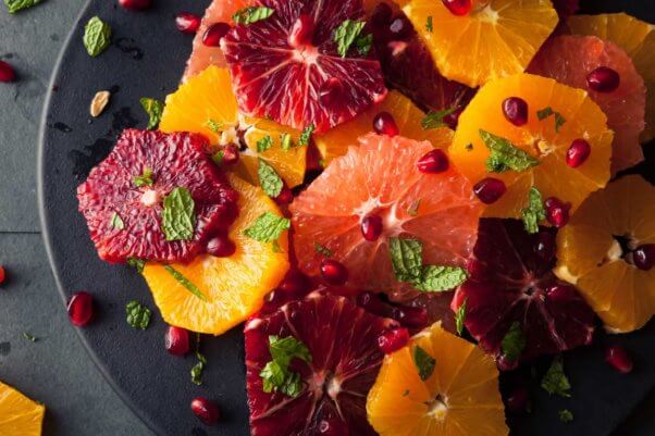 Colorful citrus fruit salad on black plate