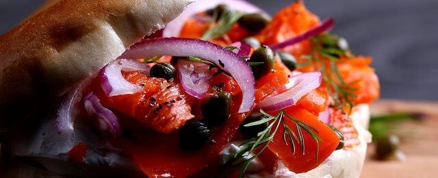 Bagel with vegan carrot lox and red onion.