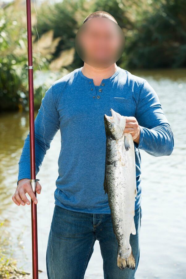 Man Fishing Holding up Dead Fish