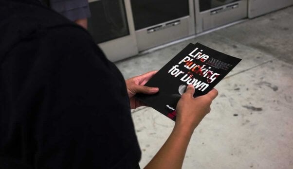 A person's hands holding a brochure titled "Live Plucking for Down"