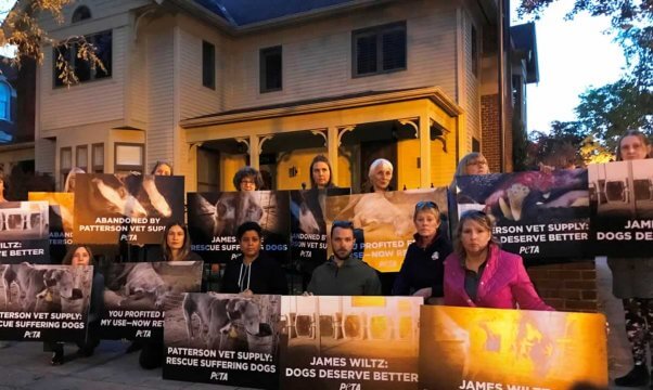 Protesters holding signs outside Patterson Vet Supply president's house