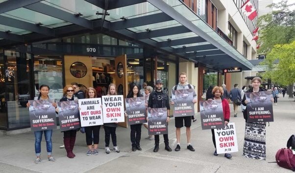 PETA supporters holding signs about the cruelty of down standing outside lululemon shareholder's meeting.