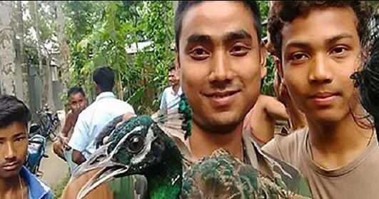 Men posing for selfie with peacock who later died