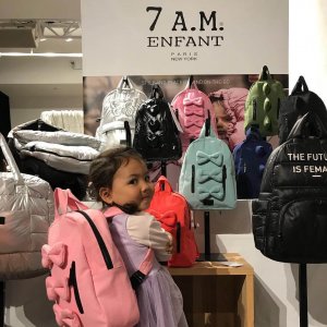 young girl standing in front of a vegan backpack display