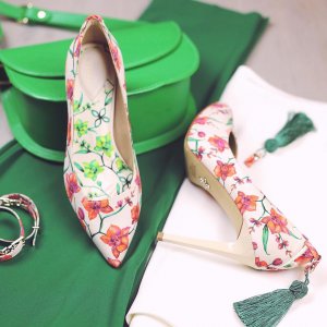 floral patterned high-heeled shoes on a green and white background