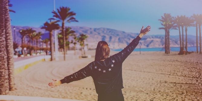 woman stretching in front of palm trees