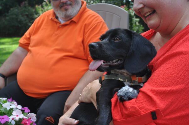 Rescued dog Buster being held by his new guardian Doris