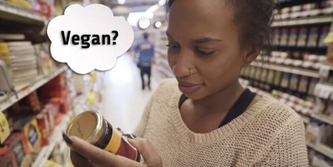 person shopping and looking at a label for the word 'vegan' instead of the often misleading term 'plant based'