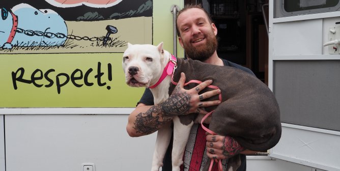 man holding dog in front of PETA mobile clinic