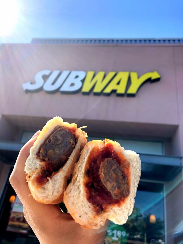 vegan meatball sub in front of Subway store sign