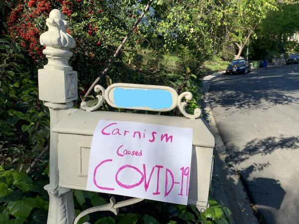 mailbox sign reads carnism caused COVID-19