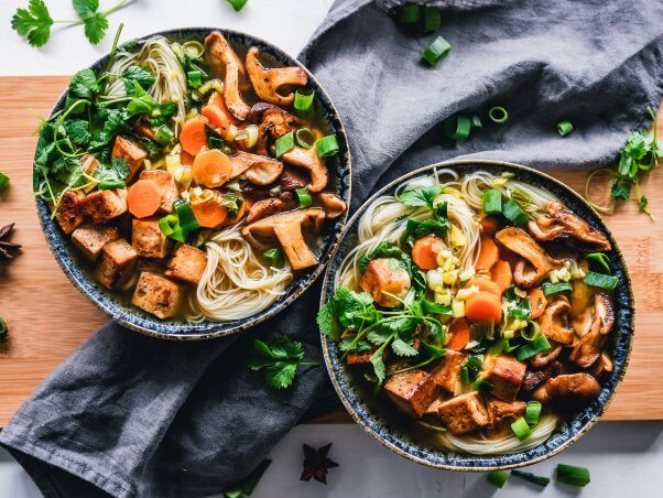 Vegan noodle bowl with tofu, mushrooms, onion, carrot