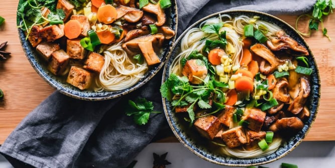 Vegan noodle bowl with tofu, mushrooms, onion, carrot