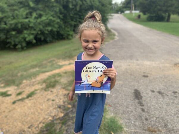 Kid with animal-friendly book from PETA's fieldworkers