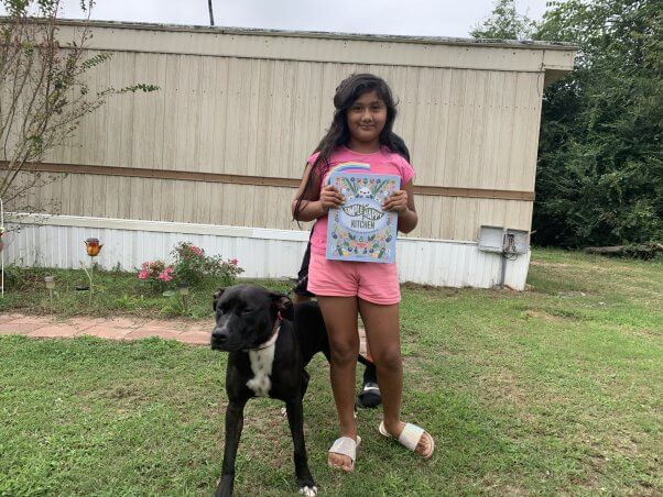 kid with animal-friendly book from PETA fieldworkers