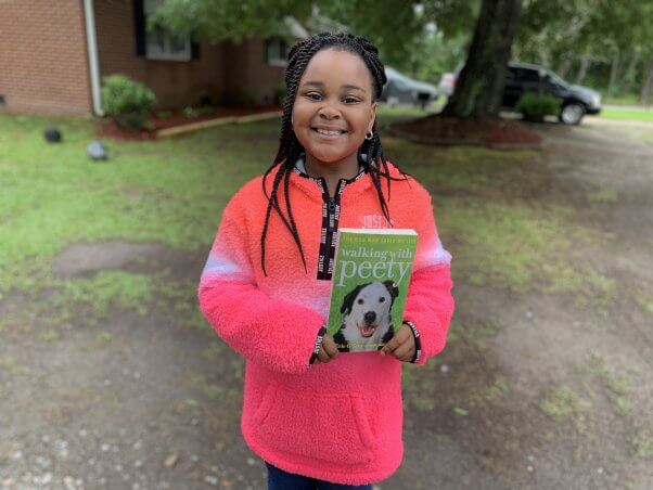 Holding Book from PETA's Barks to Books Program