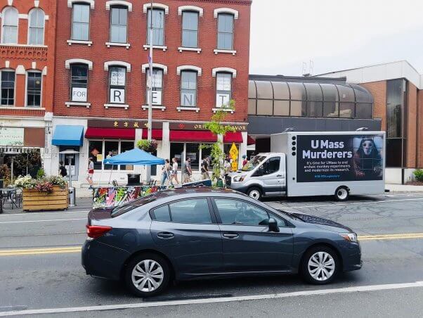 a truck with a mobile billboard that says "UMass Murderers"