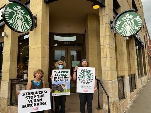 3 protestors stand outside of a Starbucks