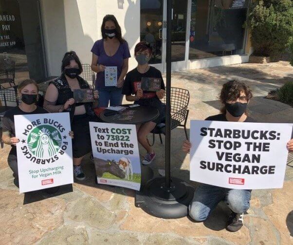 A group of PETA supporters pose for a photo with their signs outside of a Starbucks store