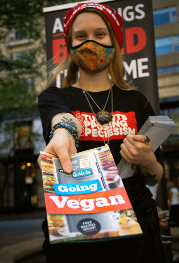 PETA SOS member with go vegan flyer