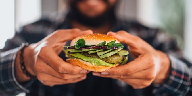 Man Holding Vegan Chickpea Burger in Hand