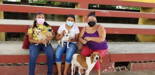 Three women and their dogs wait in line at the PETA Chichimila sterilization clini