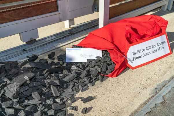 Coal spills out of a red sack delivered at Ron Coughlin