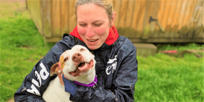 PETA Fieldworker with dog on green grass