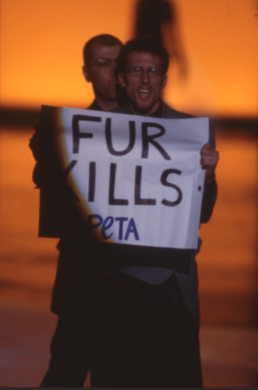 An activist with a "Fur Kills" sign crashes a Valentino show