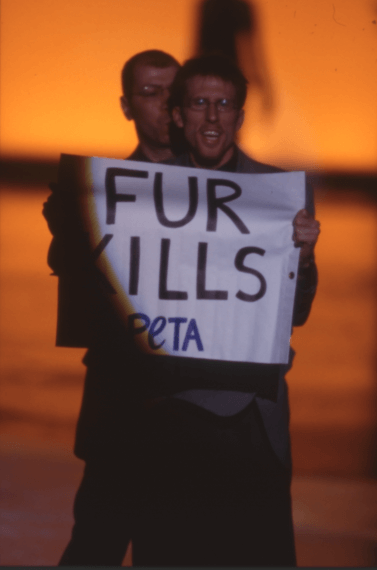 An activist with a "Fur Kills" sign suspended a show Valentino