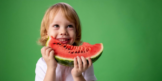Happy child eating fruit