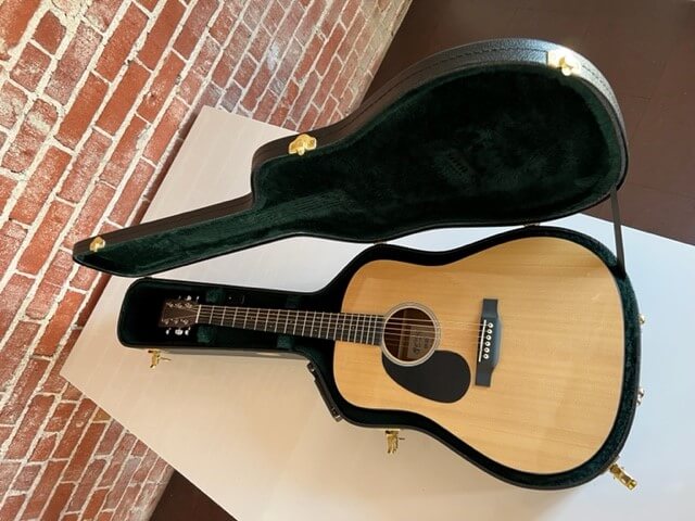 The guitar, a light beige, is shown in its case, as it will be presented in PETA's online auction