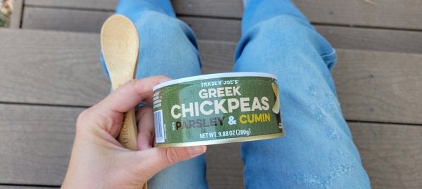 person holding a can of trader joe's greek chickpeas