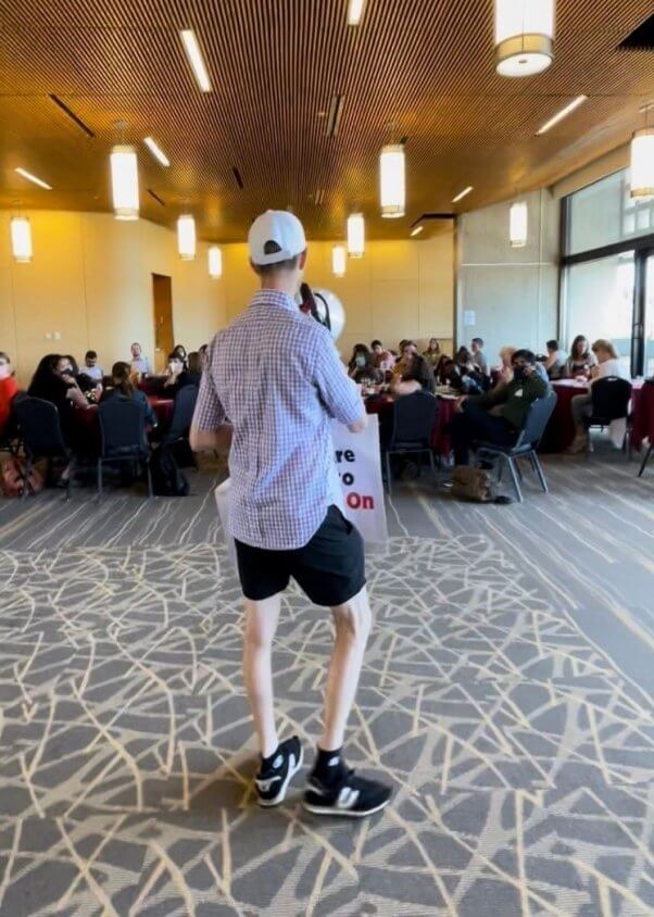 A protester holds a megaphone and sign at a UMass new faculty orientation