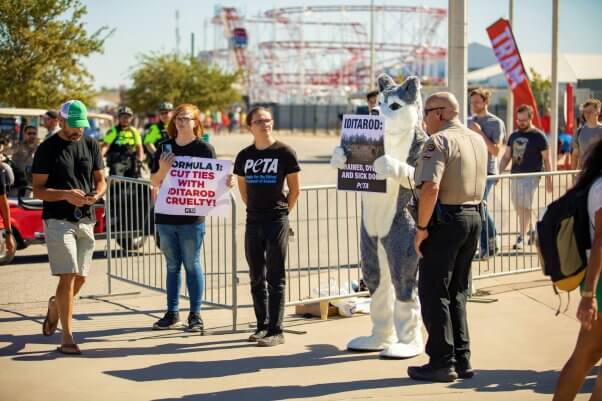 police officer and protesters against iditarod