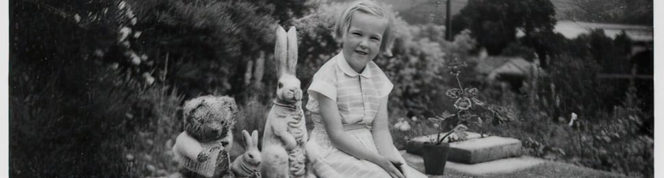 Young Ingrid Newkirk sitting on a brick ledge outside