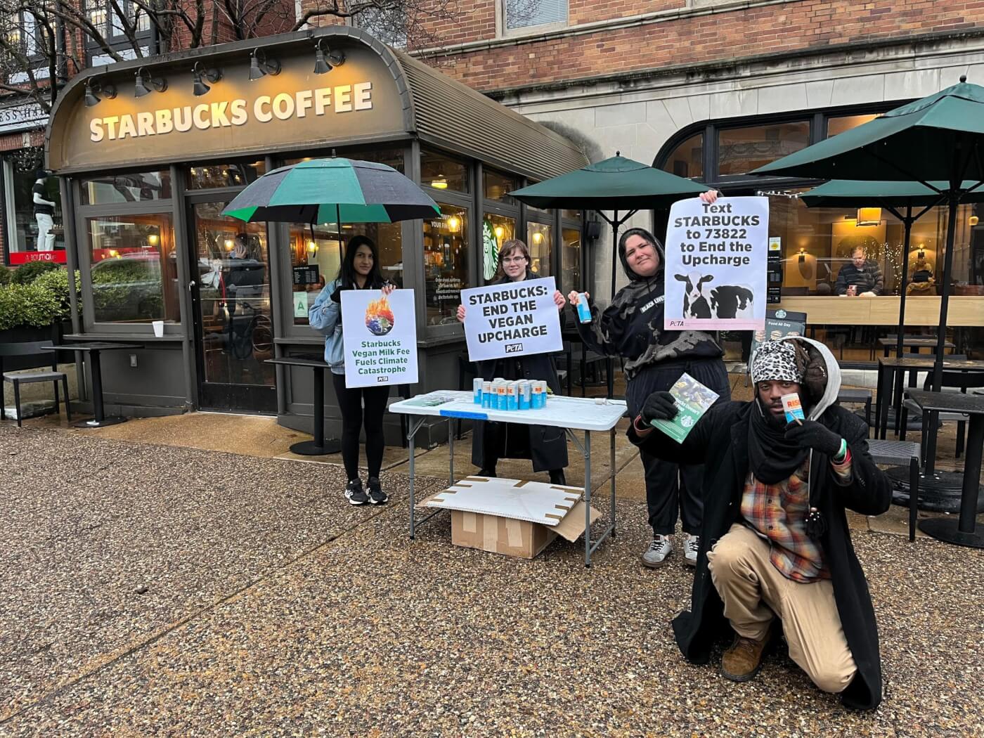 PETA protesters hold signs against dairy outside starbucks